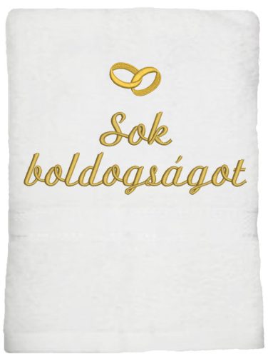Fehér hímzett „Sok boldogságot” feliratú törölköző arany gyűrűkkel, esküvői ajándék